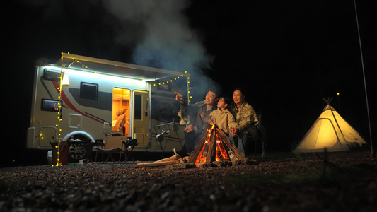 一家三口房车露营夜晚篝火取暖视频