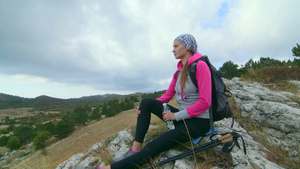 在山顶登山的年轻女性登山坐在悬崖边缘高原风景9秒视频