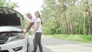 年轻夫妇在农村公路上看着汽车的引擎盖下9秒视频