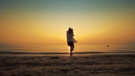 日落时在海滨翻转快乐的一对情侣视频
