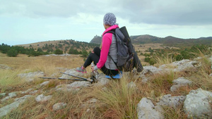 在高山高原上放松的女徒步者仰望高地16秒视频