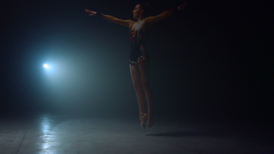 优雅艺术体操女性在聚光灯下表演体操技巧视频
