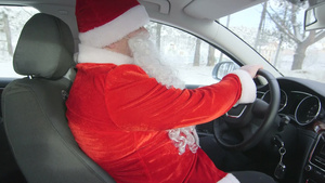 穿着圣诞老人服装的人在雪中驾驶车通过森林15秒视频