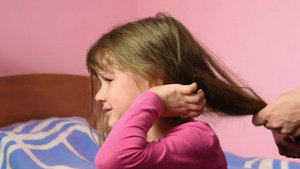 当妈妈梳缠在一起的头发时女孩感到疼痛18秒视频