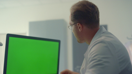 医生通过绿屏计算机检查患者肺部 X 射线特写视频