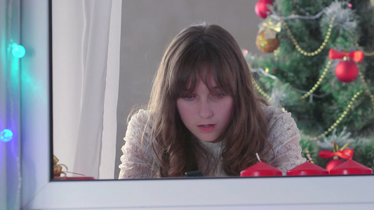 女孩在圣诞树附近使用智能电话视频