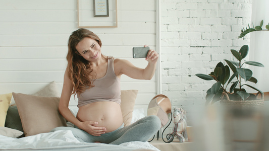 怀孕孕妈在家用手机自拍视频