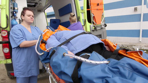 急救人员用安全带把高级病人固定在担架折叠式真空床垫上8秒视频