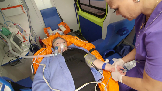 女性医护人员向准备在救护车中静脉注射输液视频