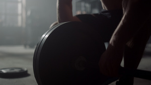 男性运动员准备运动器材进行锻炼把盘子放在杠铃上12秒视频
