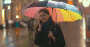 黑发女人在雨天在街上讲电话18秒视频