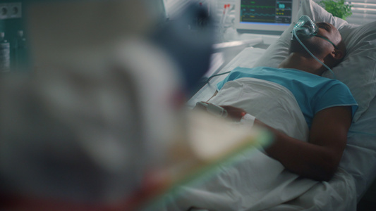 带氧气面罩躺在床上的病人医生检查病史特写视频