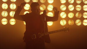 专业男性吉他手在背光下唱歌站在舞台上表演歌曲11秒视频