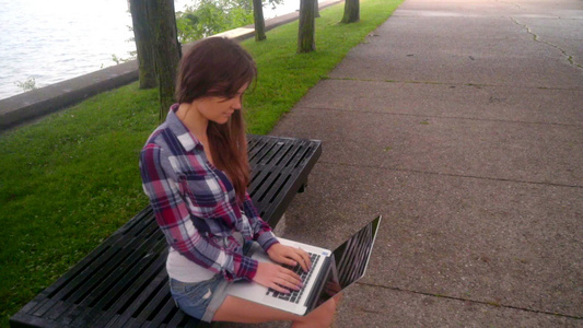 年轻女性打笔记本电脑、女孩在外面使用笔记本电脑、妇女在外面使用笔记本电脑视频