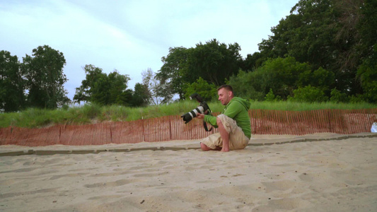 摄影师拍照人类在沙滩上使用专业摄影师视频