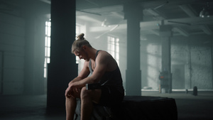 健身男性运动员坐在轮胎上在锻炼之间休息23秒视频