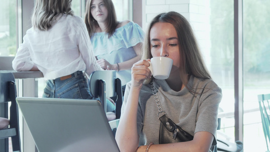 快乐的年轻女子享受在咖啡店用笔记本电脑工作视频