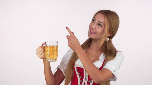 迷人性感的巴伐利亚女人拿着啤酒杯指着复制空间视频
