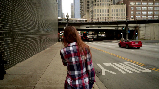 年轻女性在现代城市使用智能电话说视频