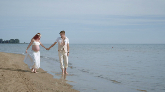 情侣漫步海滩海滩上的一对怀孕夫妇海滩上的孕妇视频