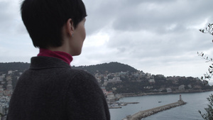 穿着灰色羊毛大衣的女人看着城市风景16秒视频