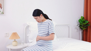 年轻孕妇坐在床上抚摸肚子24秒视频