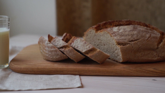 切割板上的片面包烘烤产品餐桌上的牛奶杯面包食品[切锯]视频