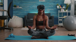 非洲裔女性在客厅里戴着vr眼镜做瑜伽16秒视频