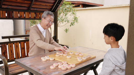 户外庭院下棋的祖孙视频