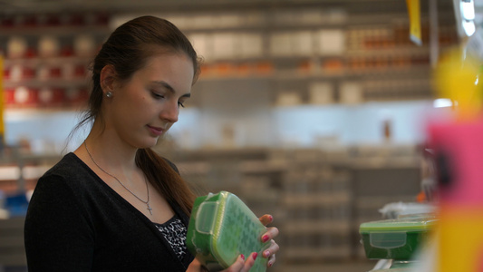 妇女在一家商店购买一个食品塑料集装箱的商店中视频