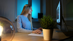 微笑的女人晚上在电脑上工作穿着格子衬衫的微笑女性坐在16秒视频