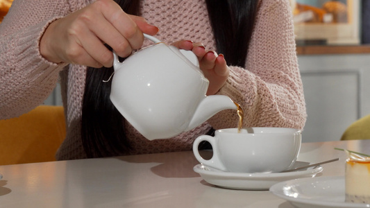 女人在咖啡店把香香茶倒进她的杯子视频