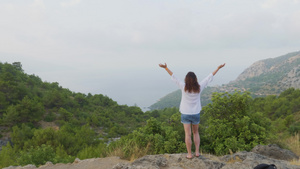 站在山顶的年轻女子举起手来14秒视频