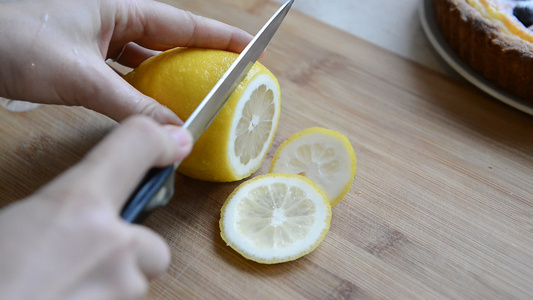 女人用刀子在砍板上切柠檬视频