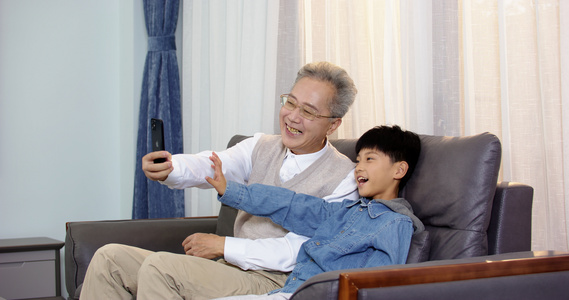 祖孙在沙发上用手机视频通话视频
