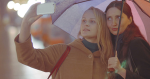 女性朋友在雨天的雨伞下拍自拍15秒视频