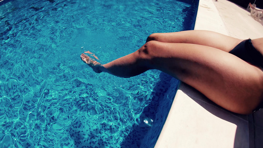 女人在游泳池里用腿喷洒和清凉的慢动作视频