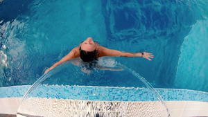 妇女在游泳池的喷水式水下享受水疗25秒视频