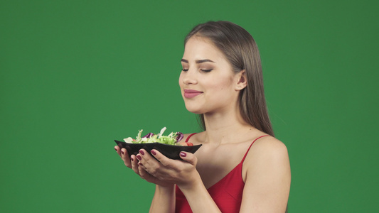 美丽美丽的健康女人闻着美味沙拉的香味快乐地微笑视频