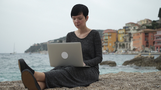 女性在海边工作在计算机上视频