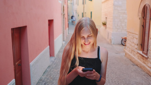 漂亮金发美女在街上散步时用智能手机聊天20秒视频