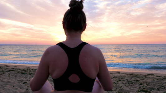 女人在沙滩上做瑜伽时的安宁和放松视频