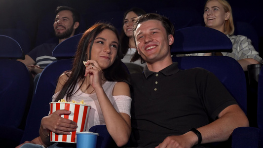 快乐的情侣在电影院看喜剧电影时大笑视频