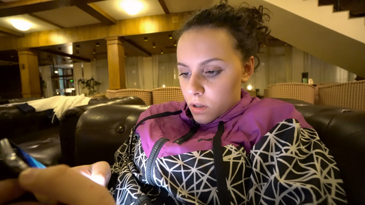 坐在沙发上的有智能手机的年轻女子视频