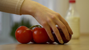 年轻妇女在厨房把新鲜蔬菜西红柿和洋葱放在桌上7秒视频