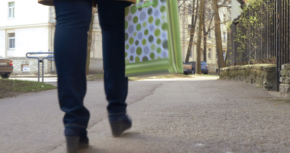 妇女用绿色购物袋走路视频