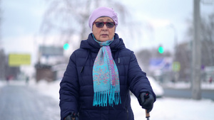 活跃的老年妇女用登山杖训练北欧式行走冬天在户外练习13秒视频