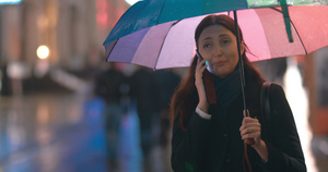 带着雨伞的年轻女子在打电话23秒视频