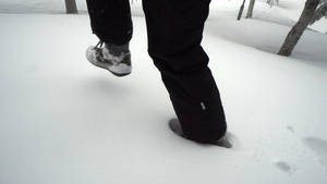 女人穿着靴子在森林里的深雪中行走11秒视频