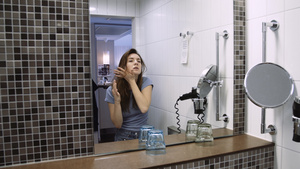 在浴室镜子2中看着令人惊讶的年轻女子28秒视频